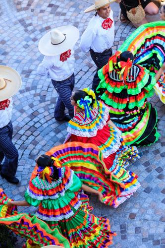 a group of people in colorful dresses on a street at La Capitale - Les Gîtes de L Argile in Barcelonnette