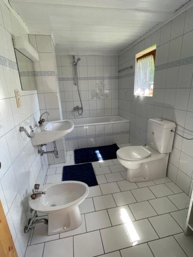 a white bathroom with a toilet and a sink at Apartments Wrolich in Latschach ober dem Faakersee