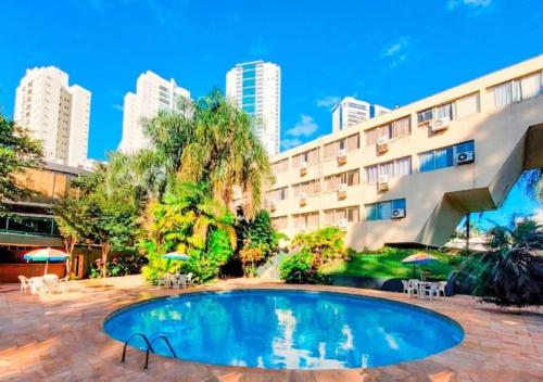 a swimming pool in front of a building at GoldMen Business Londrina in Londrina