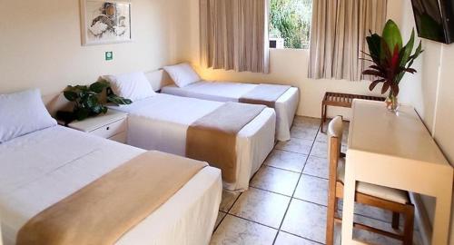 Een bed of bedden in een kamer bij Hotel do Lago