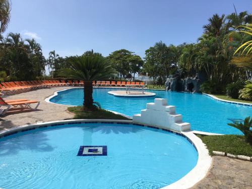 una piscina en un complejo con agua azul y una palmera en Palma Real 3xBedroom Villa Z45, en Roma