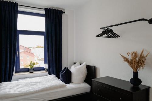 a bedroom with a bed and a window with a lamp at Designoase für 3 mit Blick auf den Wismarer Hafen in Wismar
