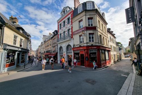um grupo de pessoas andando por uma rua com edifícios em L' Orée des brumes - Honfleur - Historic Center - 2P em Honfleur