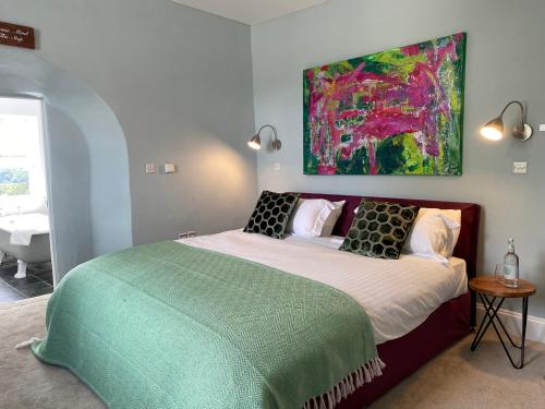 a bedroom with a bed with a painting on the wall at The Castle Inn Bradford on Avon in Bradford on Avon