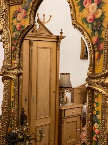 a large mirror in a room with a dresser at Casa Rosca in Sighişoara