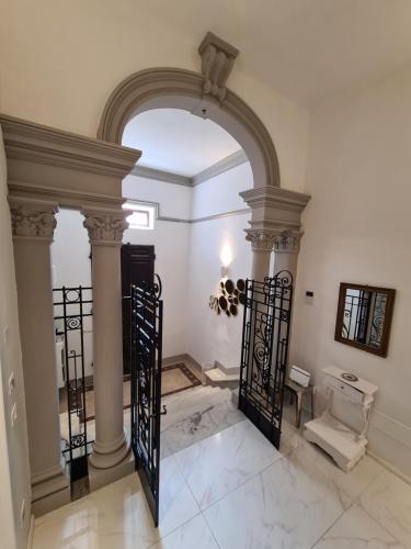 a hallway with an arch with columns and a gate at Allegra Viareggio Appartamento & Affittacamere Guest house in Viareggio