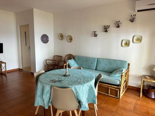 sala de estar con mesa y sofá azul en Taormina Sea house, en SantʼAlessio Siculo
