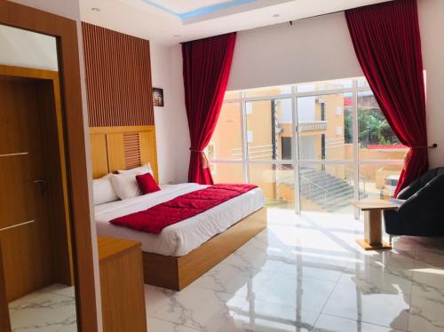 um quarto com uma cama e uma grande janela em Dominance Events and Suites em Ibadan