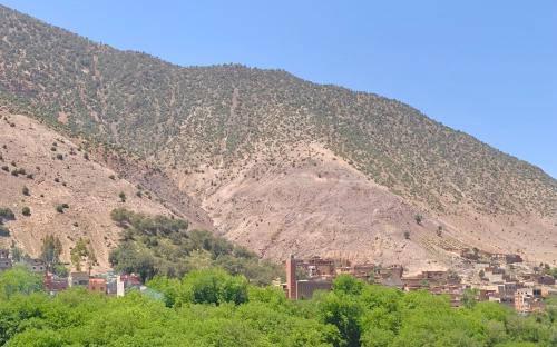 uma montanha com uma cidade em frente em Atlas Imsker em Marrakech