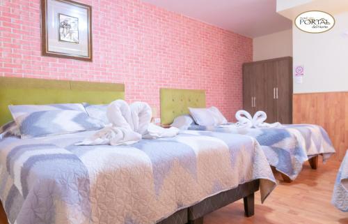 two beds in a hotel room with towels on them at Hotel Portal del Norte in Copiapó