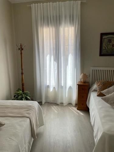 a bedroom with two beds and a window at La Casa Alandí con garaje privado in Sagunto