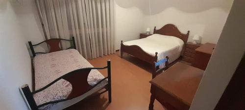 um pequeno quarto com 2 camas, uma mesa e uma cadeira em My Portugal em Vidago