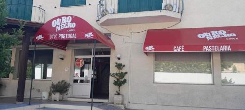 a restaurant with a red umbrella in front of a building at My Portugal in Vidago