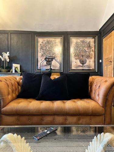 a brown couch with black pillows in a living room at Château 9 Neuf in Newark upon Trent