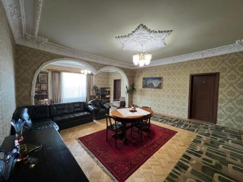 una sala de estar con una mesa y un sofá en Guesthouse Hill Side, en Kutaisi