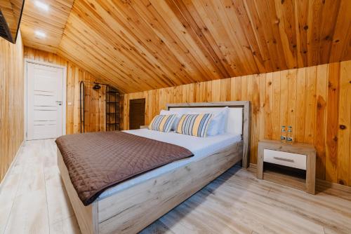 Un dormitorio con una cama en una habitación de madera. en Noua Oasis BNB with PARKING, en Brasov