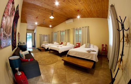 a hotel room with two beds and a couch at Soul Sync Sanctuary formally Hacienda la Moringa in Playa Hermosa