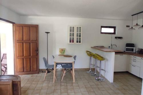 une cuisine avec une table et des chaises dans une pièce dans l'établissement Appartement au fond du jardin, à Saint Jean du Pin
