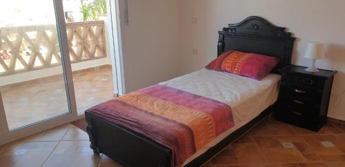 a bedroom with a bed and a balcony at Appart. 4pc à 150m², vue mer et pieds dans léau in Oued Laou