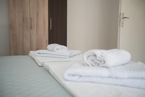 una pila de toallas en una cama frente a un espejo en Three Palms, en Gevgelija