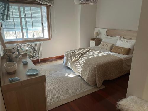 a bedroom with a bed and a window at Apartamento mirador de tambo in Combarro