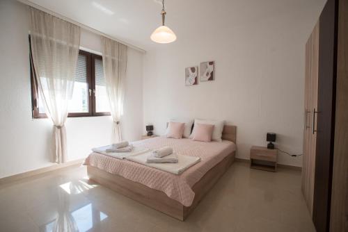 a bedroom with a bed with two towels on it at Three Palms in Gevgelija