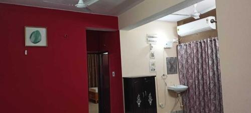 a bathroom with a red wall and a toilet at Ananya Homestay in Patna