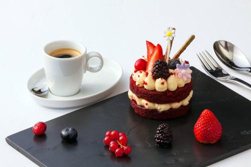 a cake on a black plate next to a cup of coffee at Sheraton Cairo Hotel & Casino in Cairo