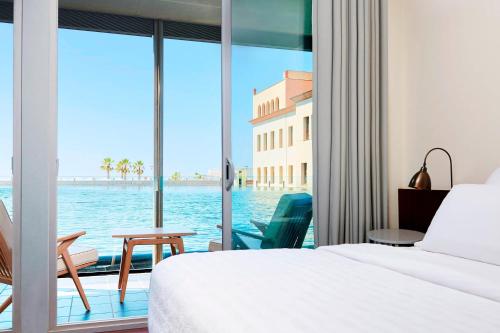 1 dormitorio con cama y vistas al agua en Le Meridien Ra Beach Hotel and Spa en El Vendrell
