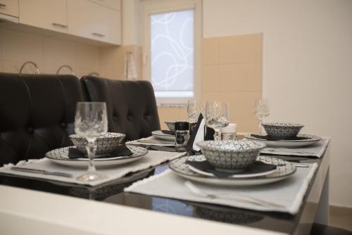 a table with plates and wine glasses on it at Three Palms in Gevgelija