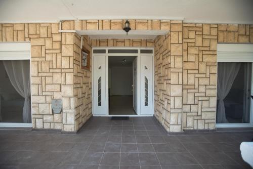 a building with a stone wall with two windows at Three Palms in Gevgelija