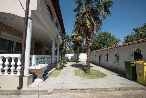 a sidewalk next to a building with a palm tree at Three Palms in Gevgelija