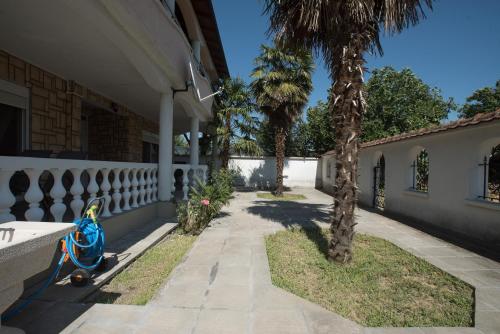 a porch of a house with two palm trees at Three Palms in Gevgelija