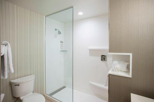 een badkamer met een toilet en een glazen douche bij Courtyard by Marriott Albany Clifton Park in Clifton Park