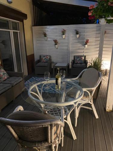 una mesa de cristal y sillas en una terraza con una mesa y copas de vino en Przystanek surfera, en Rumia