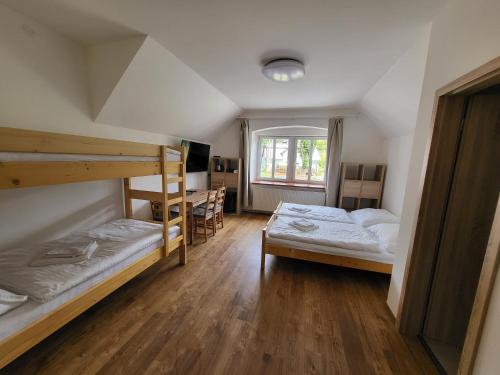 a bedroom with two bunk beds and a desk at Penzion U Kovárny in Malá Morávka