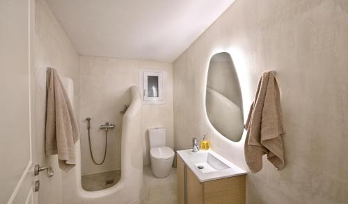 a bathroom with a sink toilet and a mirror at VLIA MAR Myconian Residences in Kalafatis