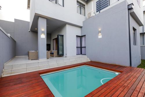 a swimming pool in the backyard of a house at Eagle of Kawele 3-bedroom villa in Sandton