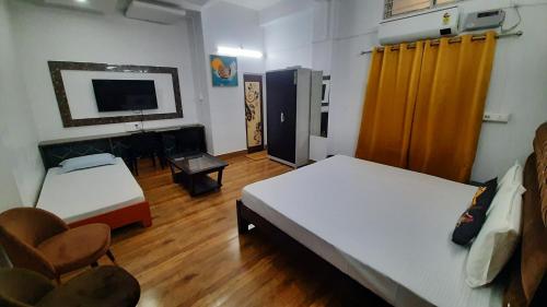 a room with two beds and a television in it at The PALM SUITES , Incredible India Tourism in Guwahati