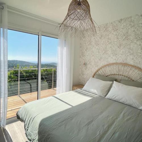 une chambre avec un lit et une grande fenêtre dans l'établissement CASA ANPÀ - Mini Villa Vue Mer Ste Lucie de Porto-Vecchio, à Lecci