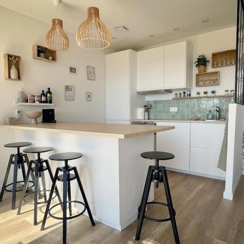 une cuisine avec trois tabourets de bar et un comptoir dans l'établissement CASA ANPÀ - Mini Villa Vue Mer Ste Lucie de Porto-Vecchio, à Lecci