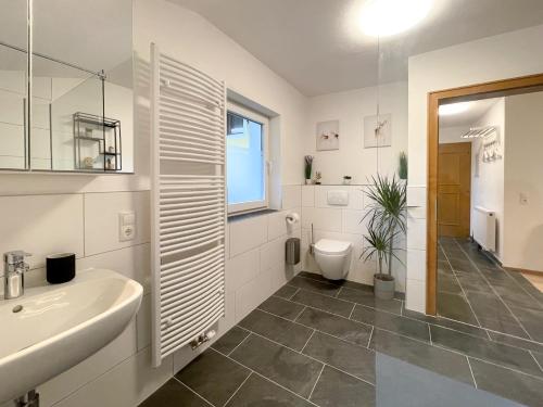 a white bathroom with a sink and a toilet at Haus Sabine in Leutasch