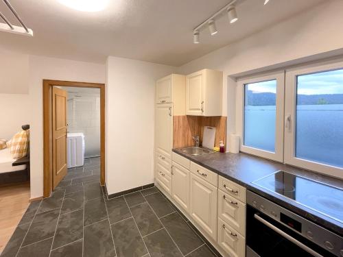 a kitchen with white cabinets and a large window at Haus Sabine in Leutasch