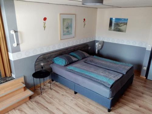 ein Schlafzimmer mit einem blauen Bett in einem Zimmer in der Unterkunft Pension Hubertus in Oberraden