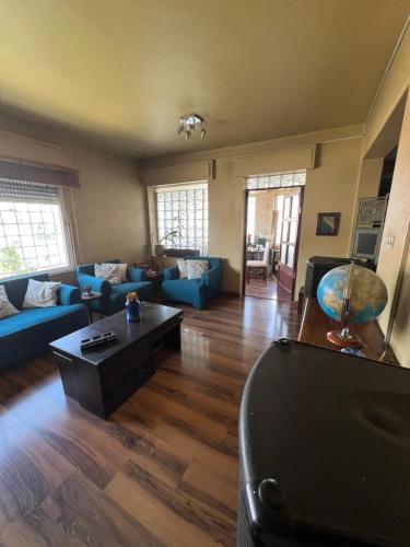 a living room with blue couches and a coffee table at Comfy place in Amman