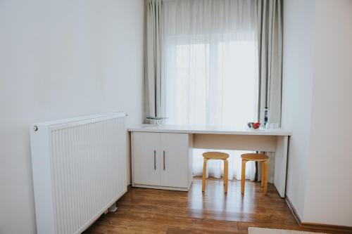 a kitchen with two chairs and a table and a window at Camelia's cozy place in Baia Mare