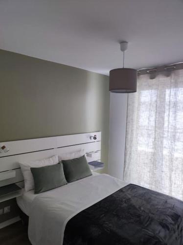 une chambre avec un grand lit et une fenêtre dans l'établissement Proche de Paris T3 tout confort, Évry-Courcouronnes