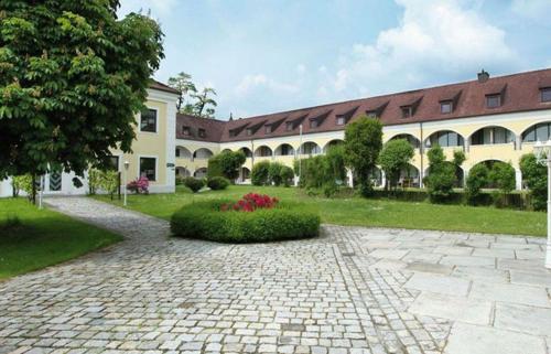 a courtyard with a large building and a brick driveway at Schloss Kirchham in Kirchham