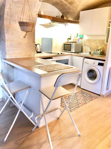 - une cuisine avec un comptoir et un lave-linge dans l'établissement Grand studio sur jardin en centre-ville, à Uzès