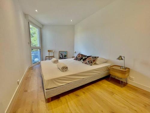 une chambre avec un grand lit et un parquet dans l'établissement PGH N19-Centre-Ville, Plage à 200m, Parking Privé, à La Grande Motte